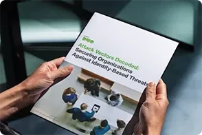 A person holds an eBook titled "Attack Vectors Decoded: Securing Organizations Against Identity-Based Threats" with the Duo logo visible.